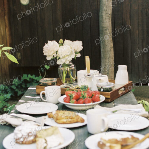 Breakfast table with tea, pastries and fresh strawberries. Breakfast table with tea, pastries and fresh strawberries.