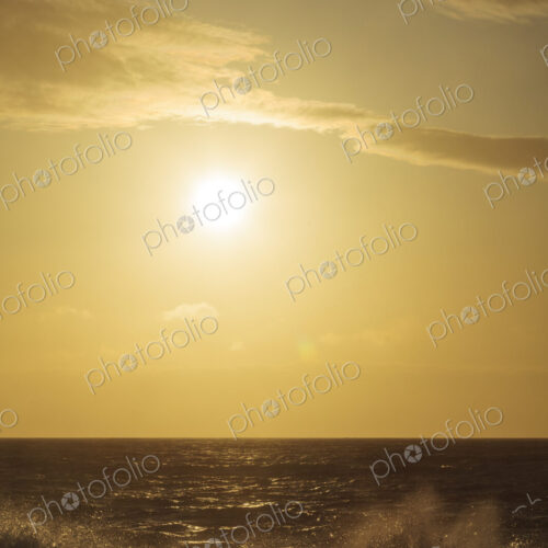 Breaking ocean waves, reflections and white water, a bright sun in the sky Breaking ocean waves, reflections and white water, a bright sun in the sky