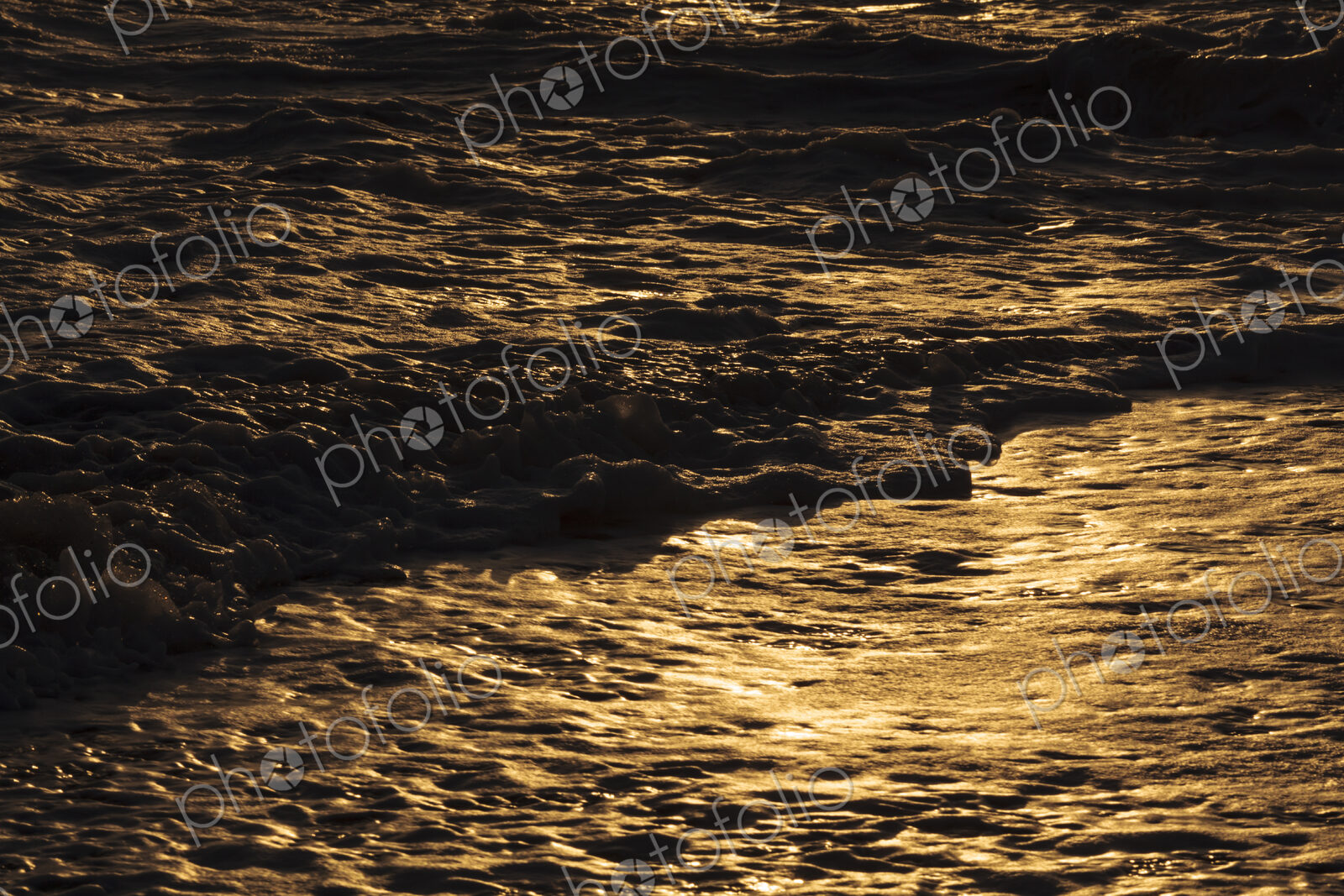 Breaking ocean waves, shadows and light reflections on the water surface.