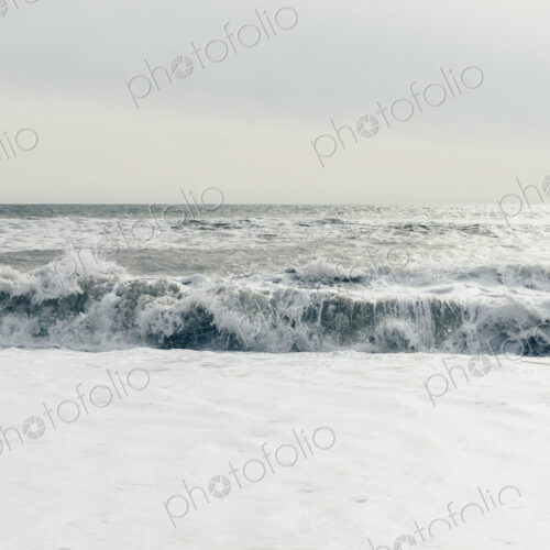 Breaking waves, surf in the ocean and waves, moody overcast sky above Breaking waves, surf in the ocean and waves, moody overcast sky above