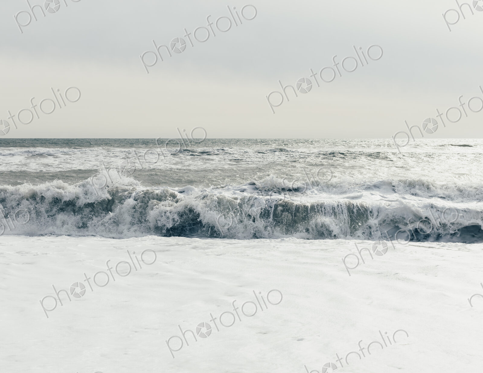 Breaking waves, surf in the ocean and waves, moody overcast sky above