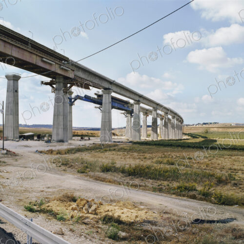 Bridge under construction, pillars and elevated road across an arid landscape. Bridge under construction, pillars and elevated road across an arid landscape.