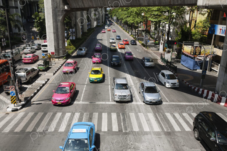 Bright coloured taxis and other cars in Bangkok traffic.