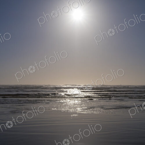 Bright sun over vast ocean and beach Bright sun over vast ocean and beach