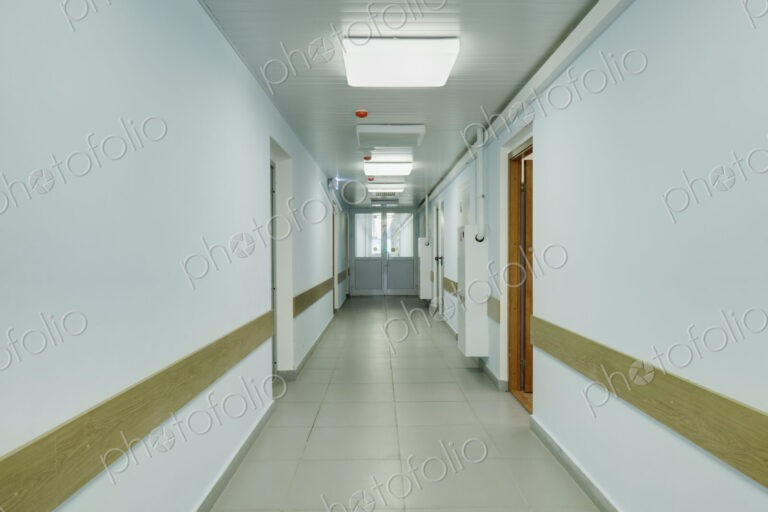 Brightly lit corridor in a sports hall with doors leading off it.