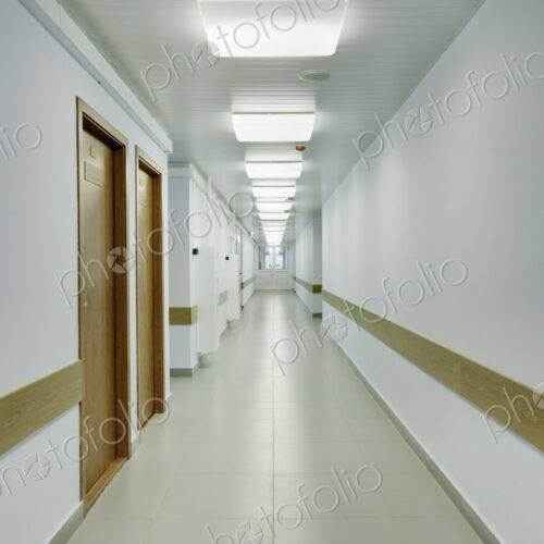 Brightly lit corridor in a sports hall with doors leading off it.