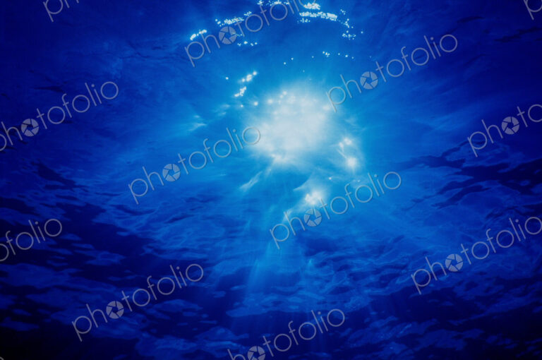 Brilliant Crepuscular rays and a sunburst shining through moving water, view from…