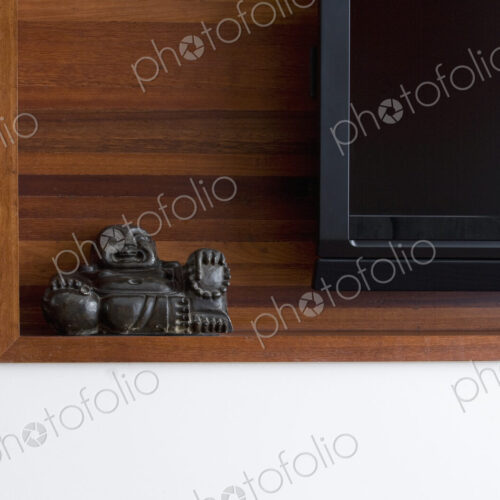 Buddha statue on shelf with TV.