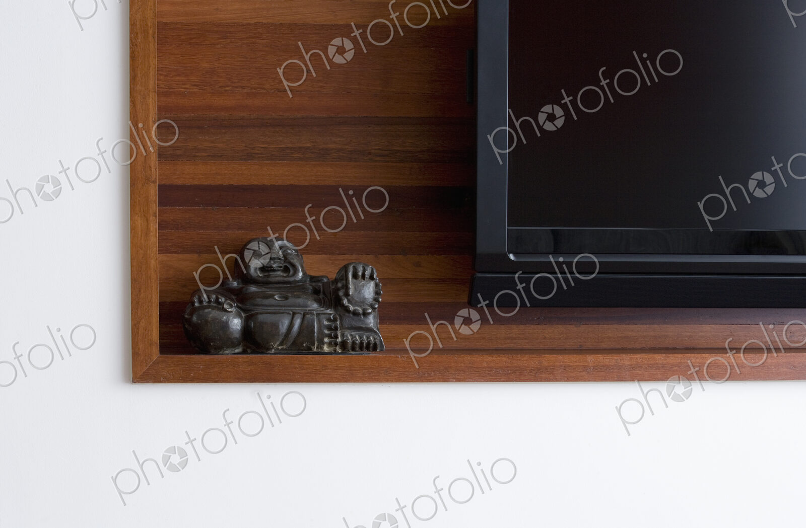 Buddha statue on shelf with TV.
