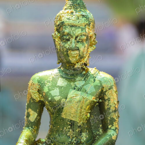 Buddha statue with gold leaf flaking at the Grand Palace Bangkok. Buddha statue with gold leaf flaking at the Grand Palace Bangkok.