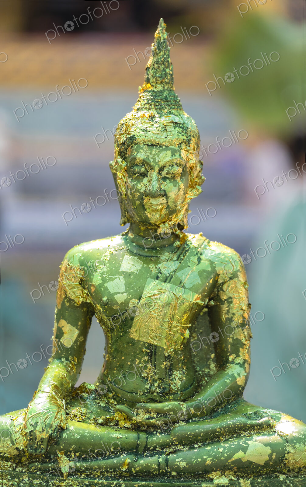 Buddha statue with gold leaf flaking at the Grand Palace Bangkok.