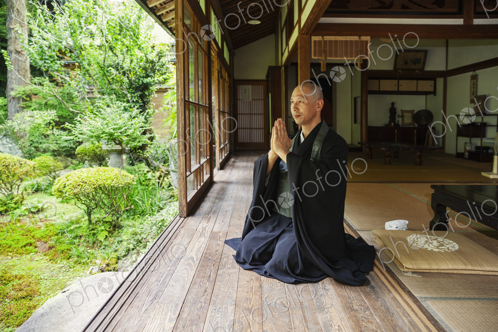 Buddhist priest kneeling in Buddhist temple, praying.