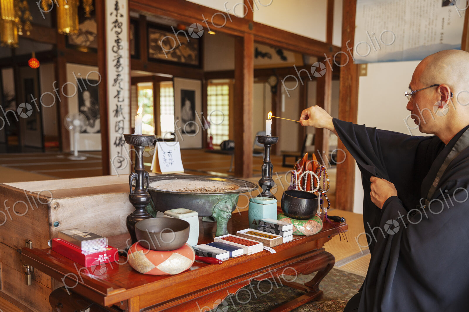 Buddhist priest kneeling in Buddhist temple, praying.