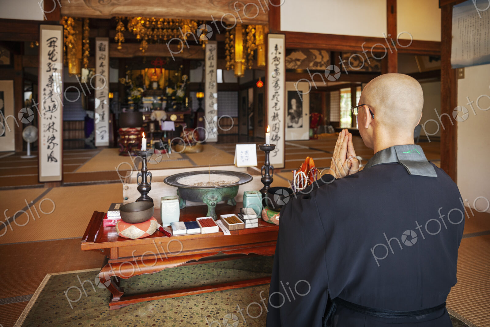 Buddhist priest kneeling in Buddhist temple, praying.