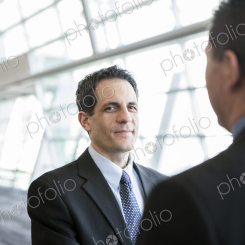 Businesman looking at the camera during discussion in a conference centre lobby.