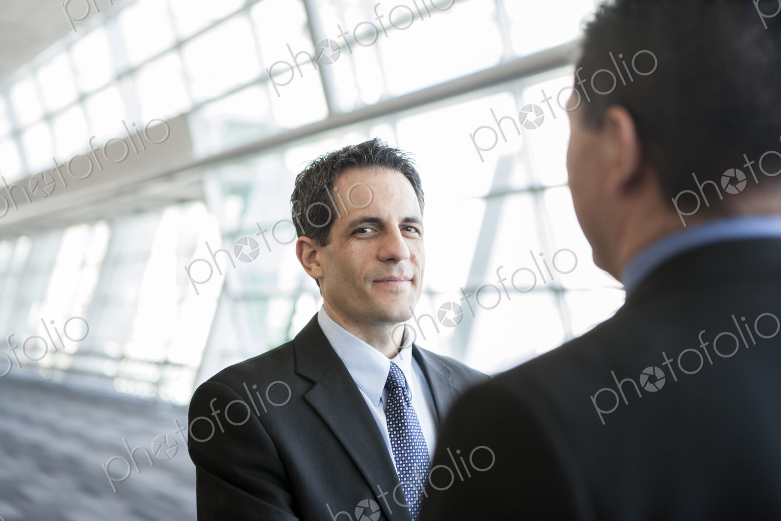Businesman looking at the camera during discussion in a conference centre lobby.