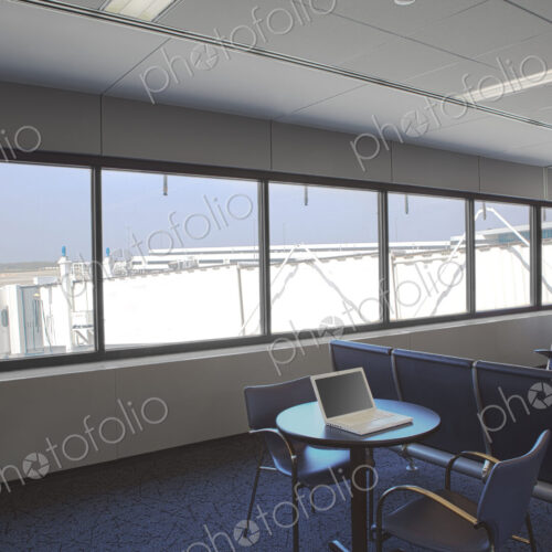 Business airport lounge, view outside and a laptop on a table