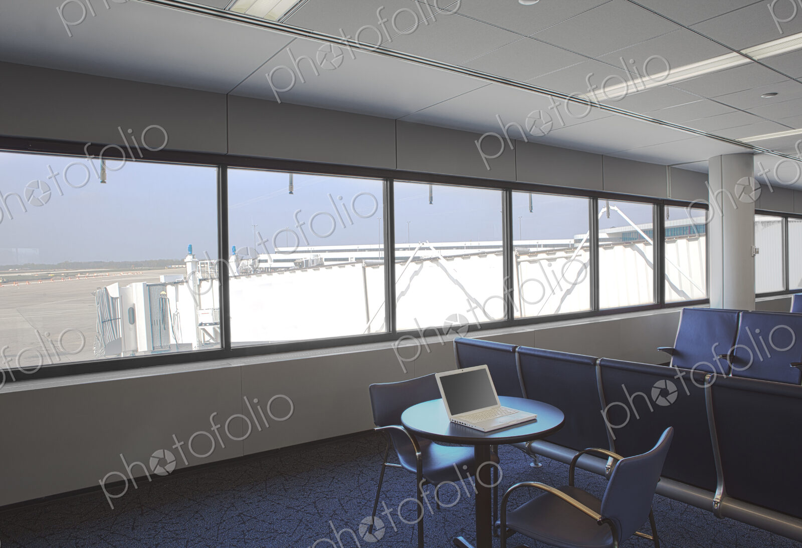 Business airport lounge, view outside and a laptop on a table
