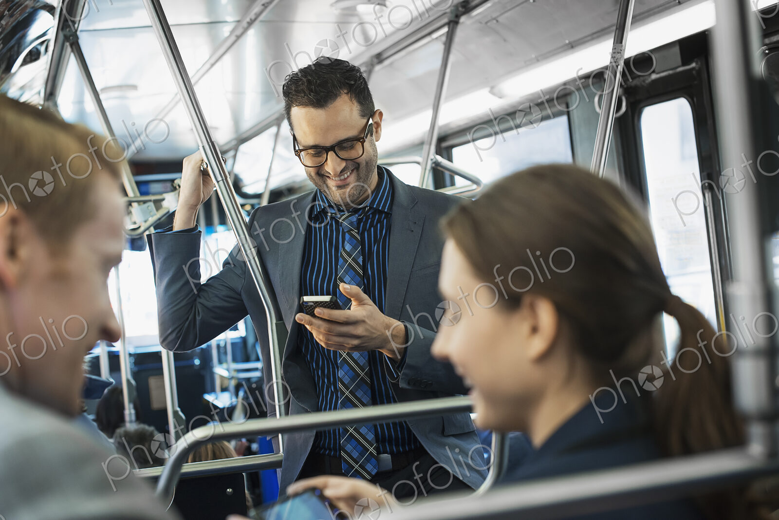 Business people in the city. Three people on the move, two men and a woman, on the bus.