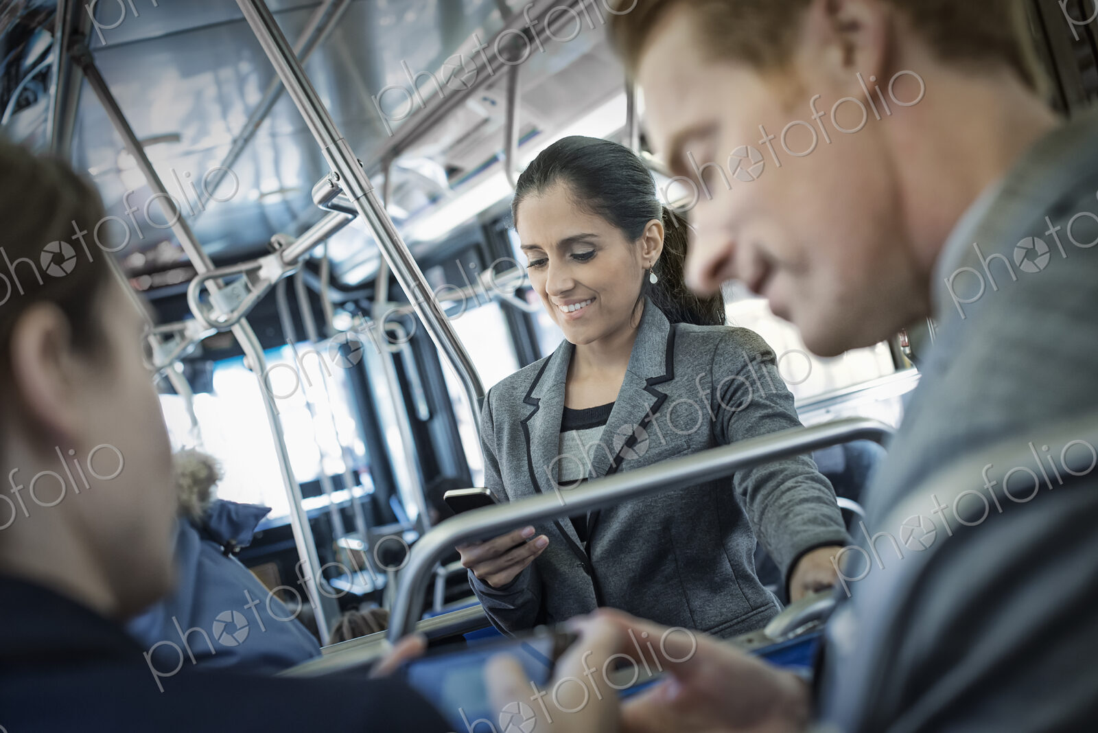 Business people in the city. Three people on the move, two men and a woman, on the bus.