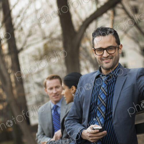 Business people in the city. Three people, two men and a woman in a city park relaxing. Business people in the city. Three people, two men and a woman in a city park relaxing.