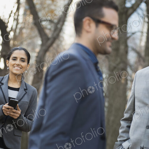 Business people in the city. Three people, two men and a woman in a city park relaxing. Business people in the city. Three people, two men and a woman in a city park relaxing.