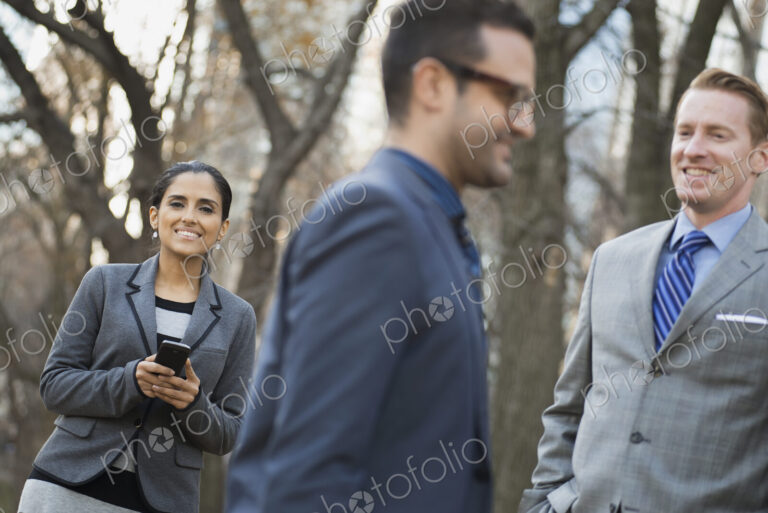 Business people in the city. Three people, two men and a woman in a city park relaxing.