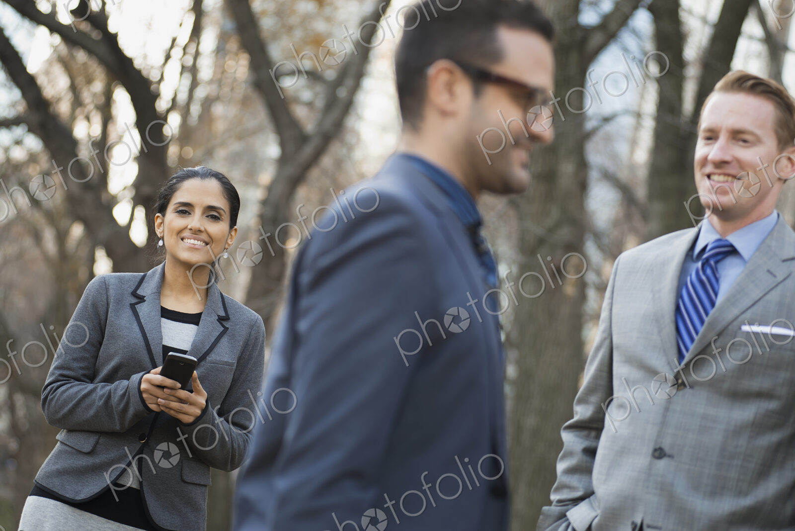 Business people in the city. Three people, two men and a woman in a city park relaxing.