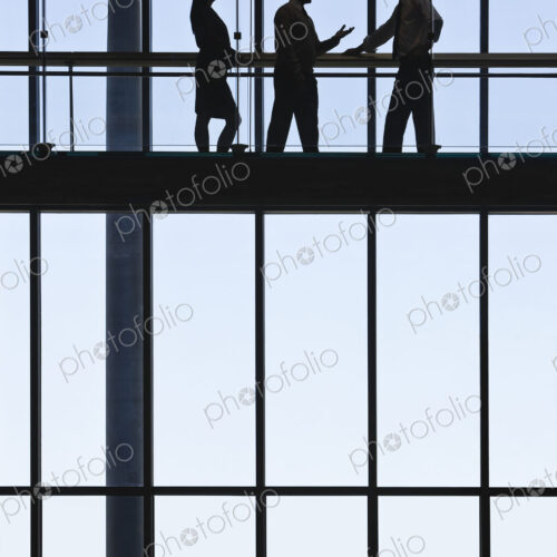 Business people meeting on an elevated walkway between office buildings. Business people meeting on an elevated walkway between office buildings.