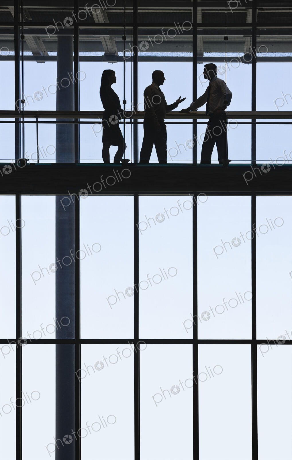 Business people meeting on an elevated walkway between office buildings.
