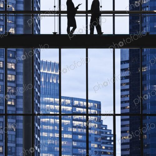 Business people meeting on an elevated walkway between office buildings. Business people meeting on an elevated walkway between office buildings.