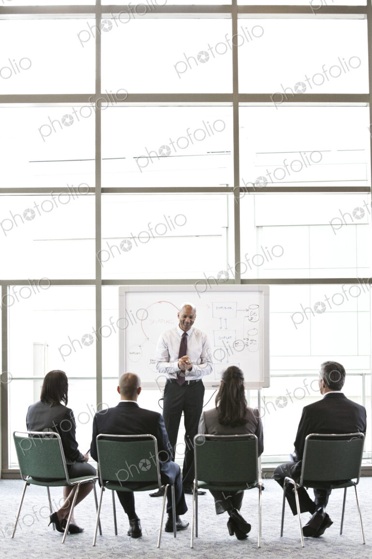 Business people sitting and watching a presentation on a white board