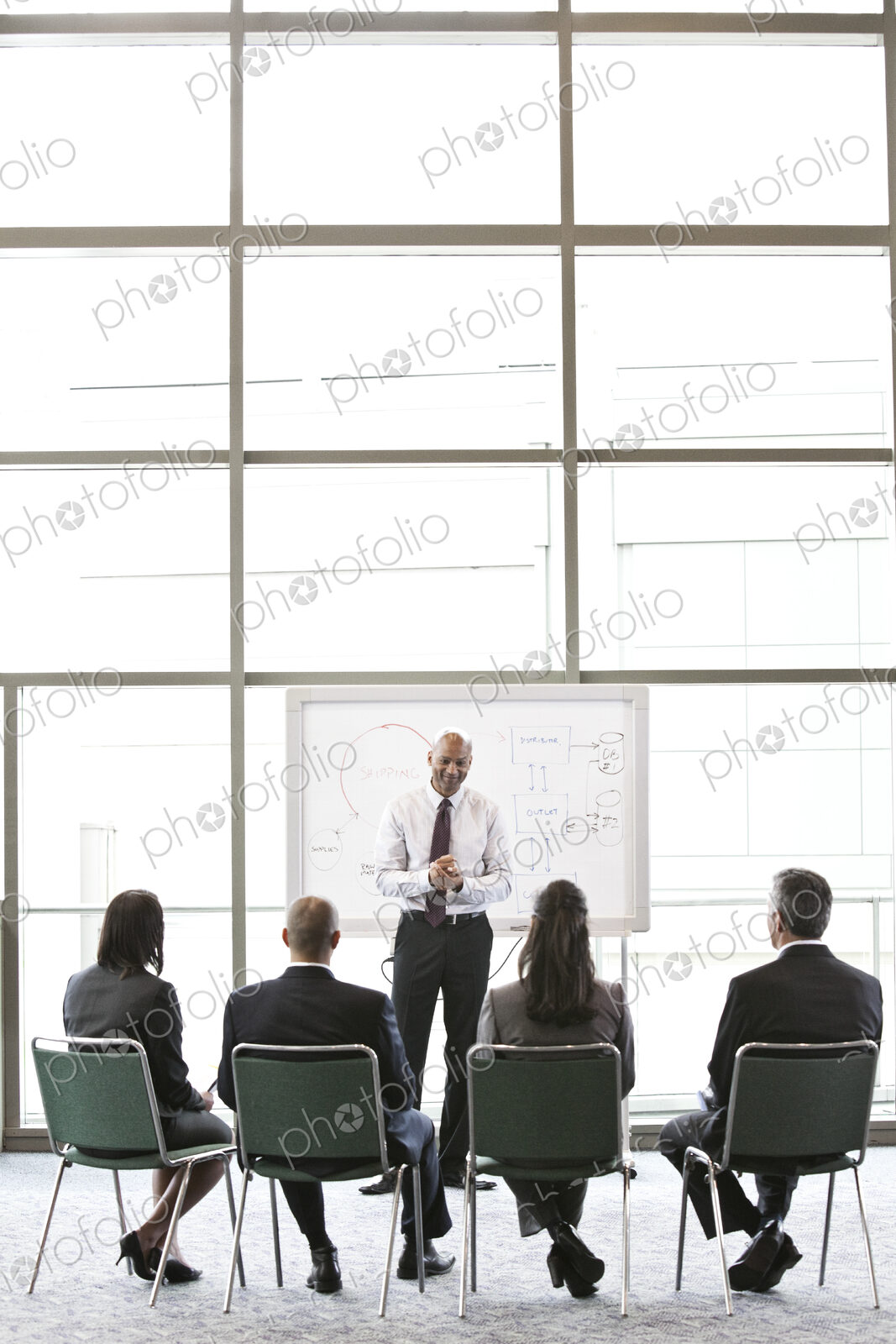 Business people sitting and watching a presentation on a white board