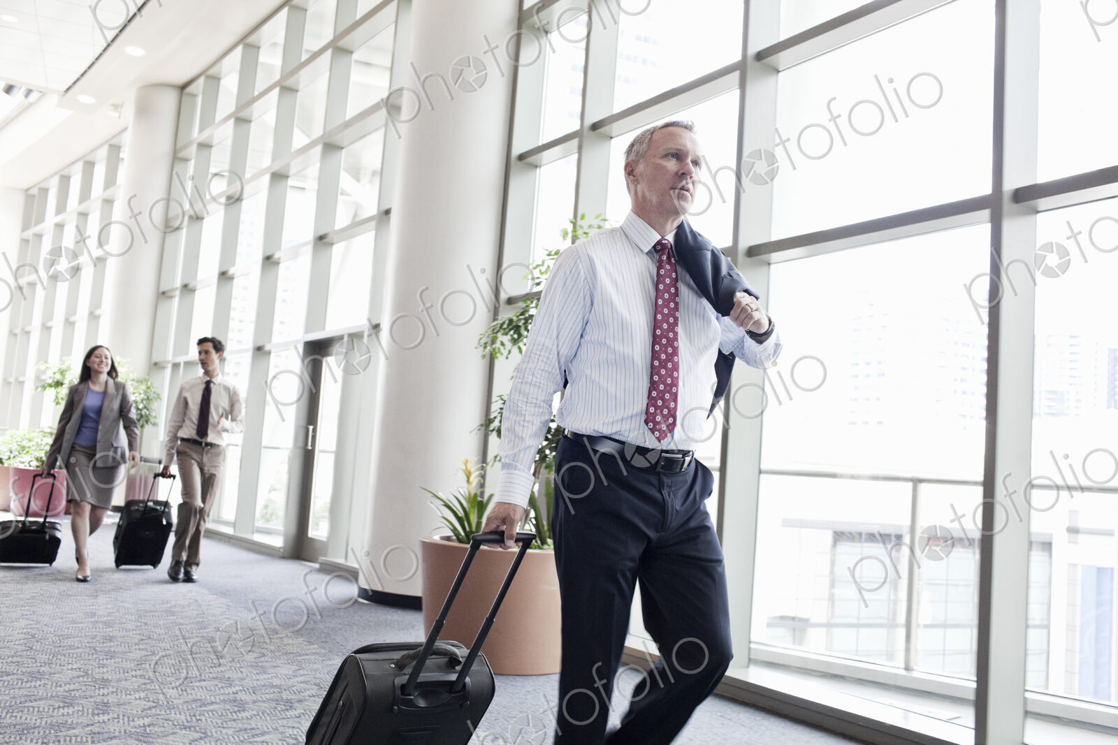 Business people walking through a covered walkway on the way to catch a plane.