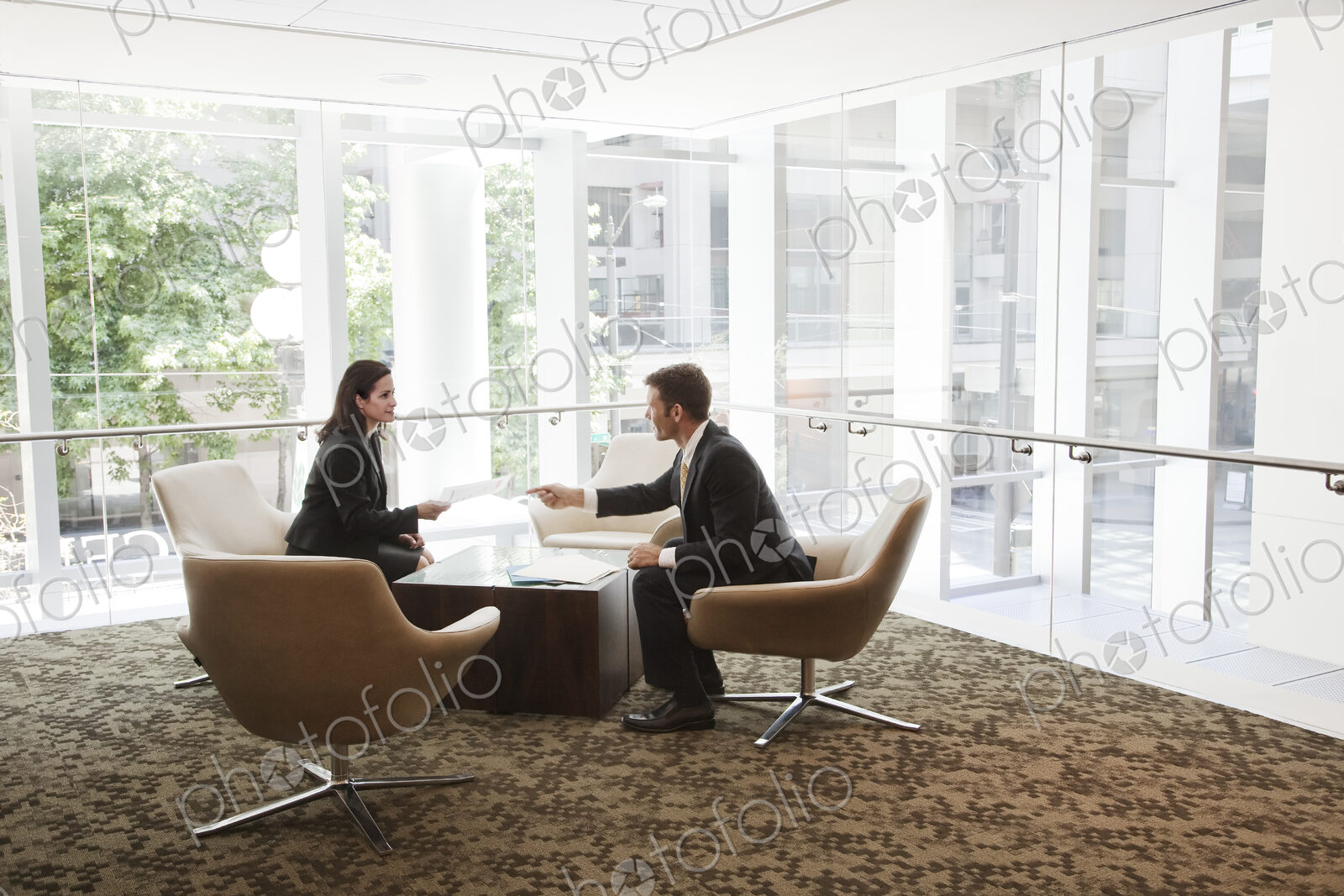 Businessman and woman meeting at a table in a large business center.