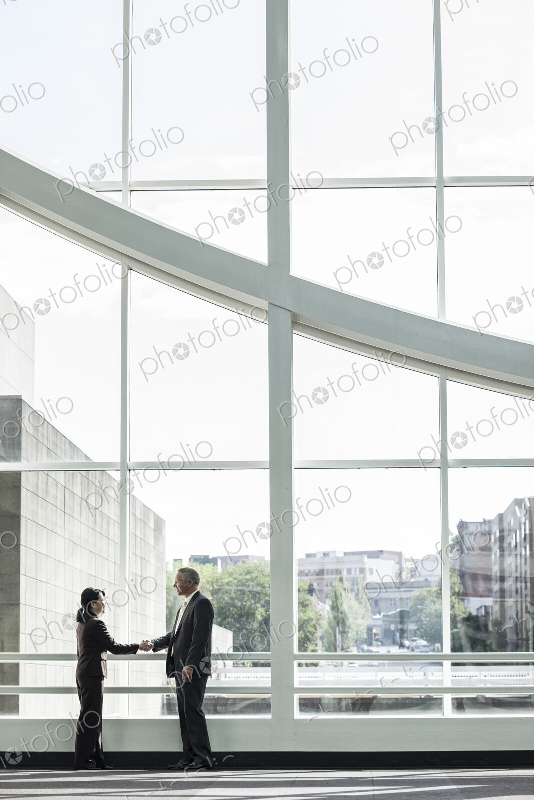 Businessman and woman meeting in a large glass covered walkway