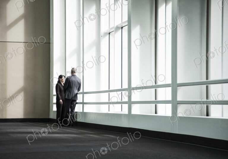 Businessman and woman meeting in a large glass covered walkway