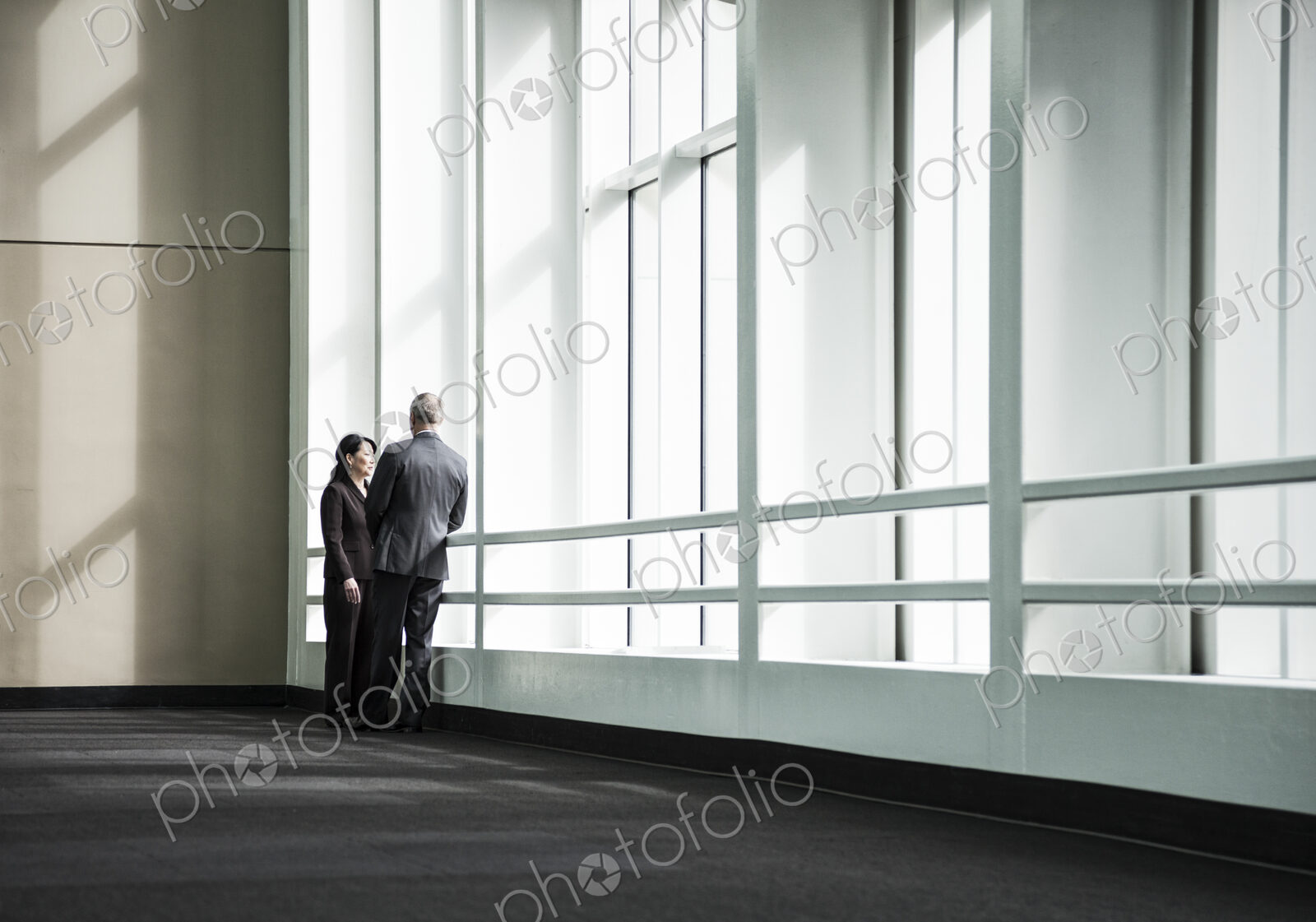 Businessman and woman meeting in a large glass covered walkway