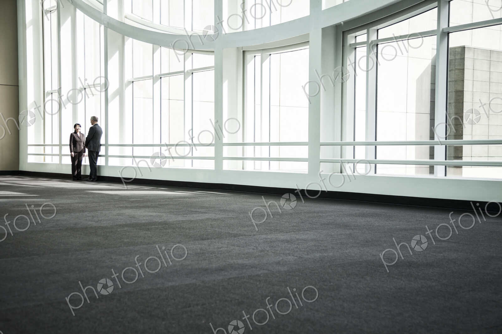 Businessman and woman meeting in a large glass covered walkway