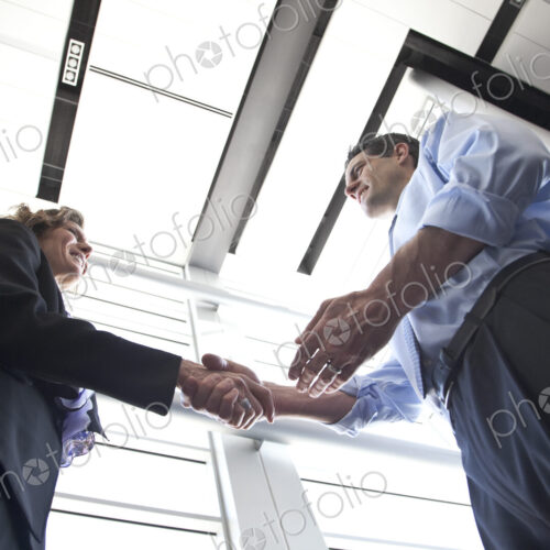 Businessman and woman meeting in the lobby of a conference centre.