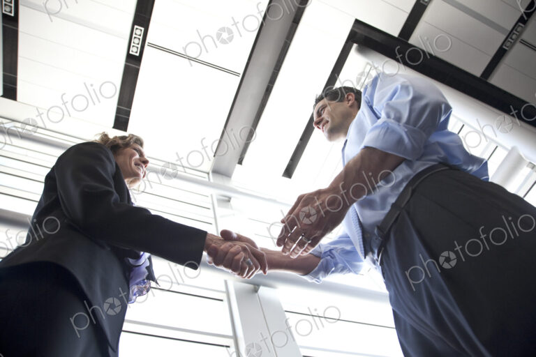 Businessman and woman meeting in the lobby of a conference centre.
