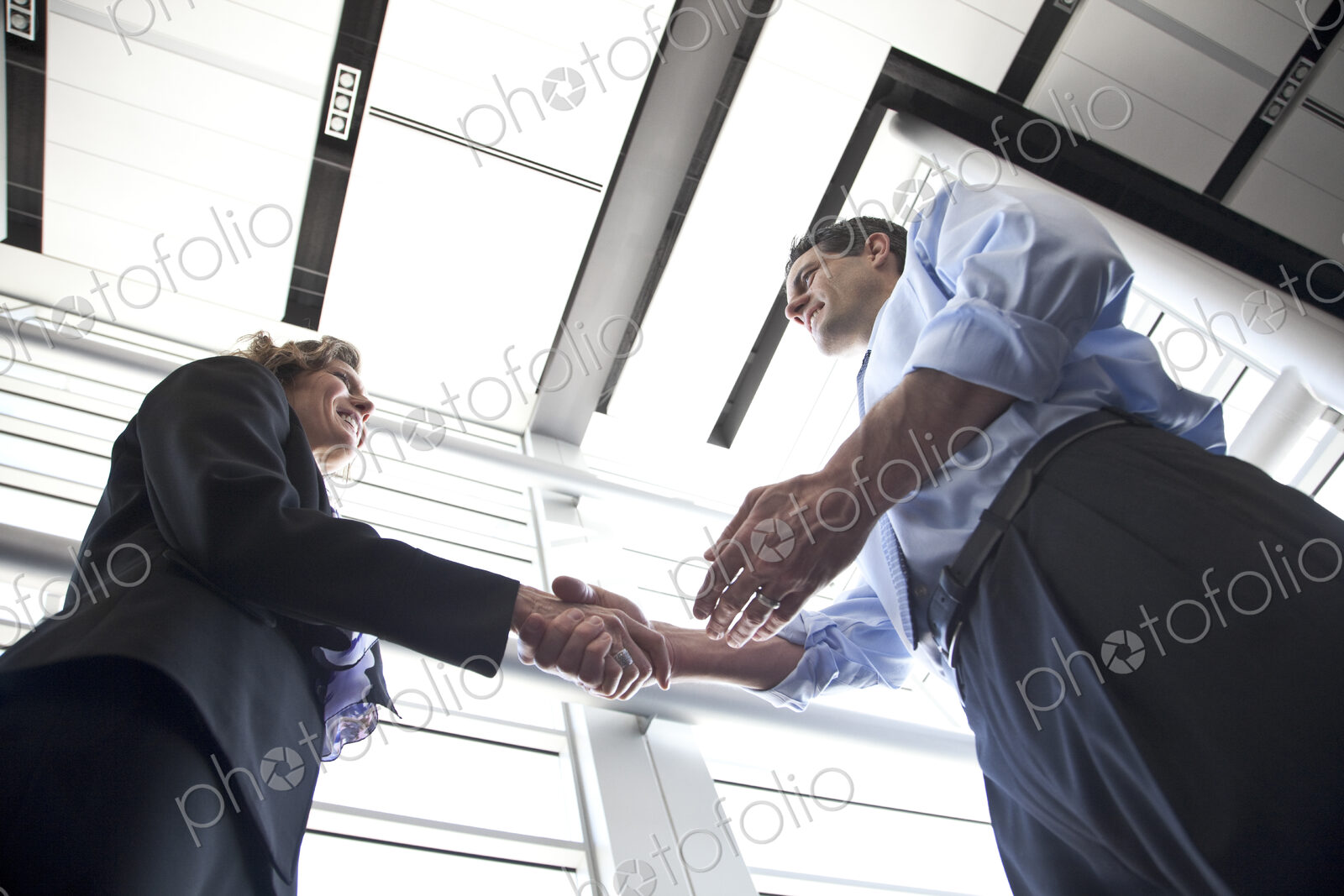Businessman and woman meeting in the lobby of a conference centre.