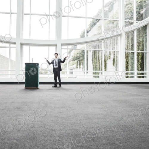 Businessman at a podium with no one to talk to.