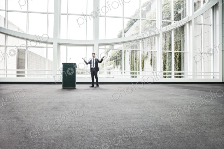 Businessman at a podium with no one to talk to.