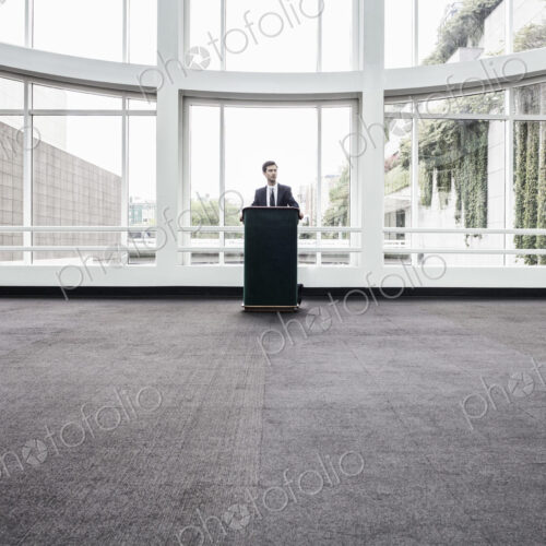 Businessman at a podium with no one to talk to.