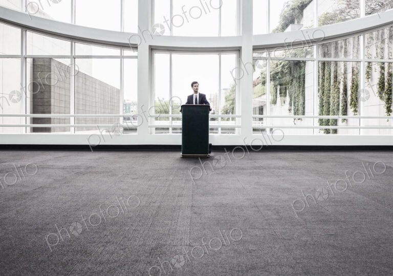 Businessman at a podium with no one to talk to.