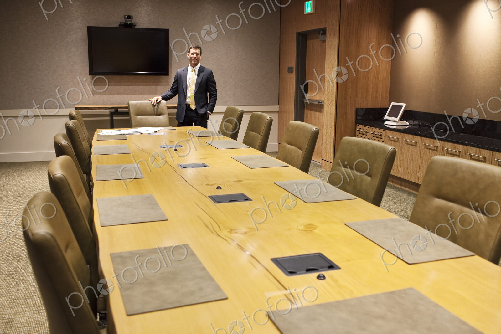 Businessman at the head of a large conference room table.