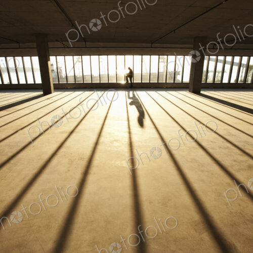 Businessman exploring new empty raw business space for a new office at sunset Businessman exploring new empty raw business space for a new office at sunset