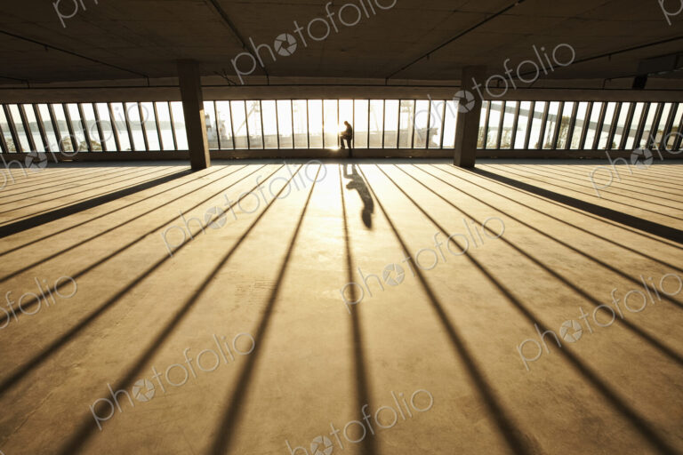 Businessman exploring new empty raw business space for a new office at sunset