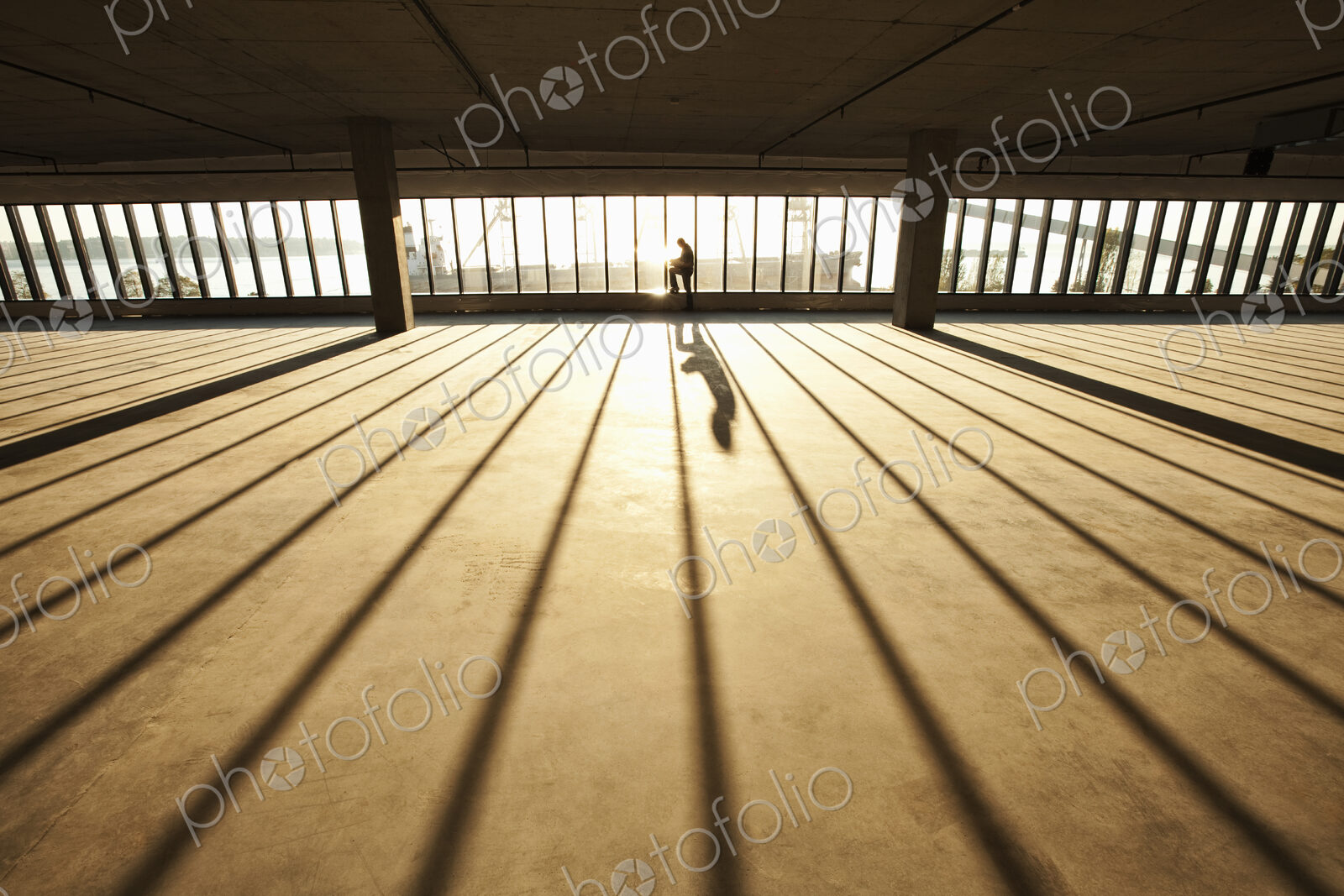 Businessman exploring new empty raw business space for a new office at sunset
